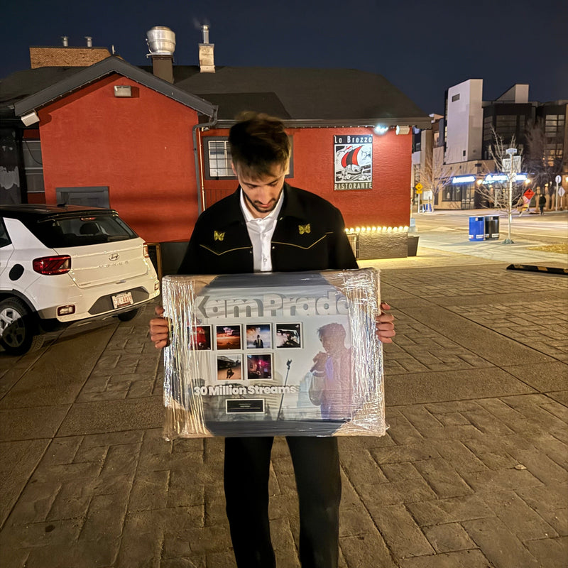 Kam Prada holding his 30 Million Streams plaque